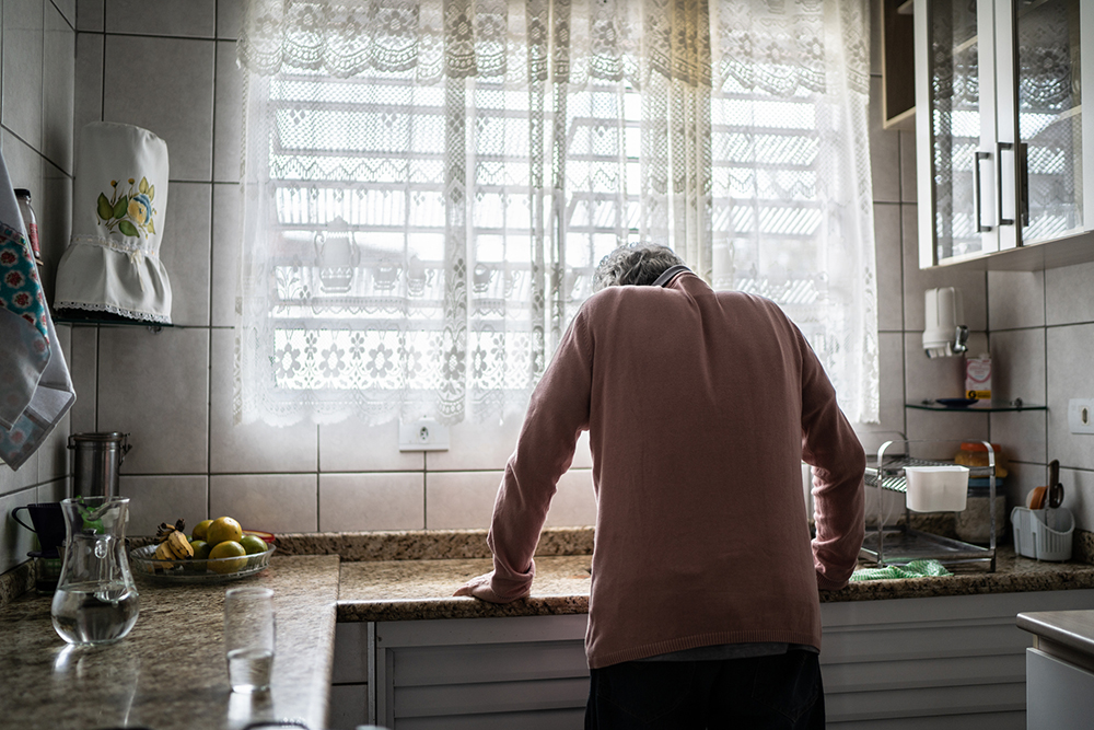 Ill man hunched over sink